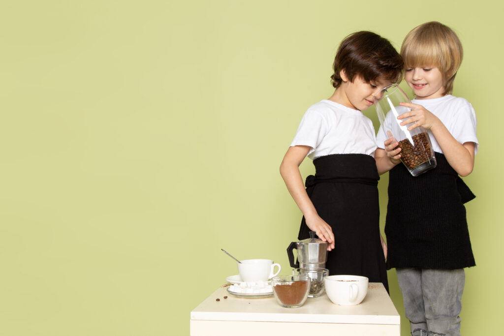 front-view-two-boys-preparing-coffee-drink-stone-colored-desk