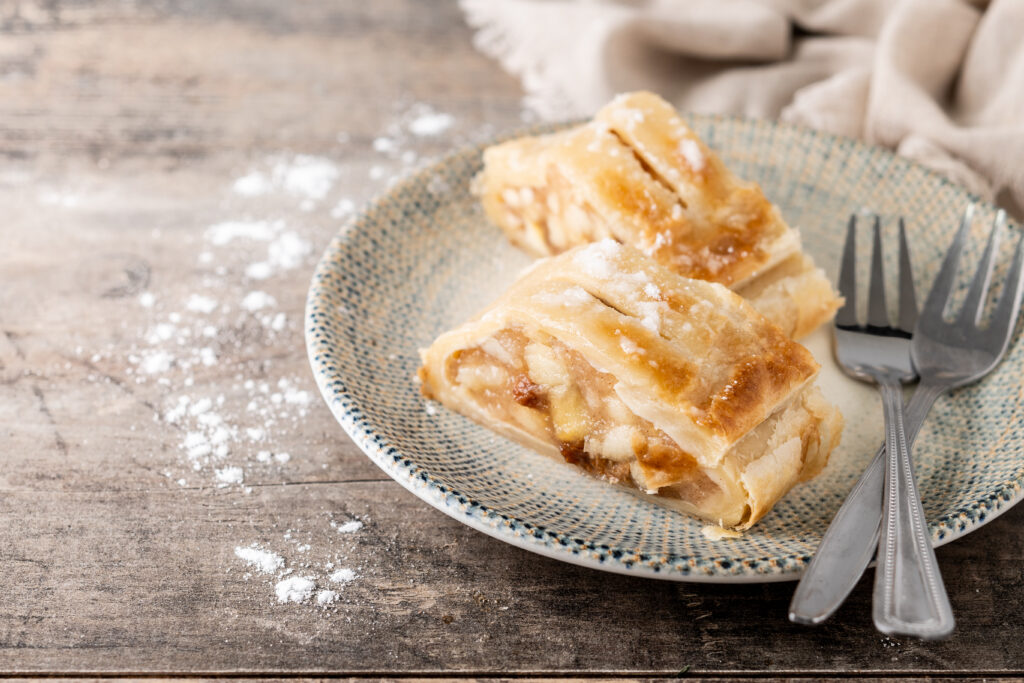 Homemade apple strudel slice on wooden table